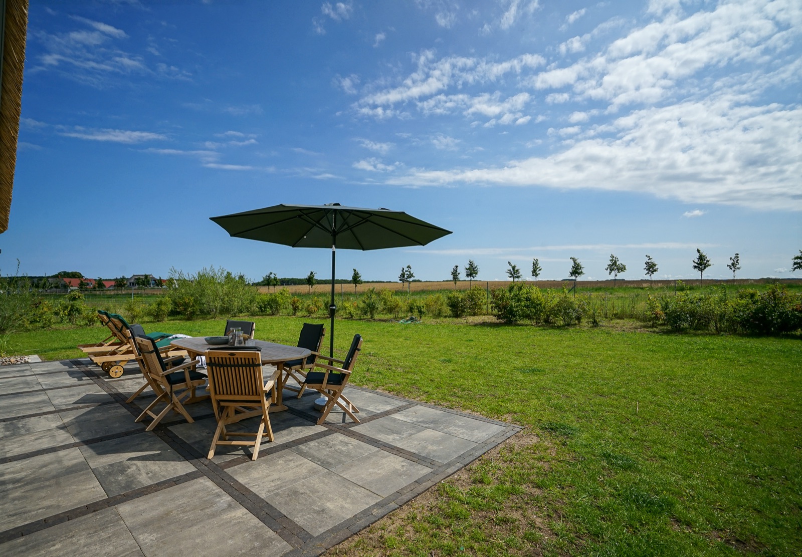 Terrasse mit Gartenmöbeln und Sonnenschirm